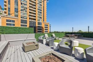 a patio with chairs and a table and a building at 2BR Modern South Loop Suite With Views & Gym in Chicago