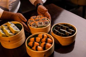 a group of four bowls of sushi on a table at Crowne Plaza Nairobi Airport by IHG in Nairobi