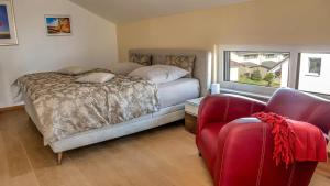 1 dormitorio con 1 cama y 1 silla roja en Alpenblick 