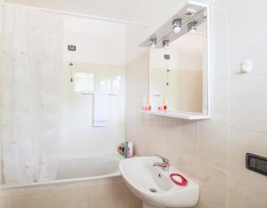 een witte badkamer met een wastafel en een bad bij Palma 9 in San Siro