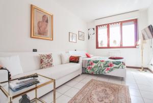 een witte woonkamer met een bank en een tafel bij Palma 9 in San Siro