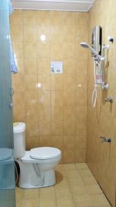 bagno con servizi igienici e telefono appeso al muro di D'TERRACE KUNDASANG a Ranau