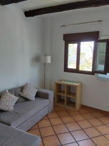 sala de estar con sofá y mesa en Valle de la Calma - Apartamentos rurales de Mecina, en Granada