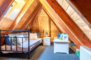 um quarto num chalé de madeira com uma cama e uma secretária em Ferienwohnung-J-Jacobs em Wrixum