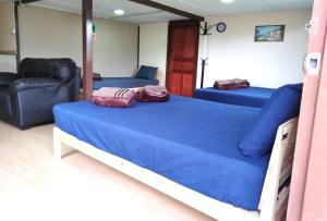 een slaapkamer met 2 bedden en een bank bij D'TERRACE KUNDASANG in Ranau
