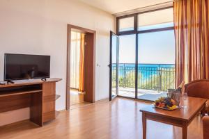a living room with a view of the ocean at Tiva del Mar Beach Hotel in Sveti Vlas