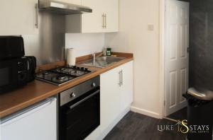 Il comprend une petite cuisine équipée d'une cuisinière et d'un évier. dans l'établissement Luke Stays - Nicholson Terrace, à Killingworth