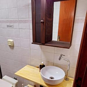 La salle de bains est pourvue d'un lavabo blanc et d'un miroir. dans l'établissement Apartamento Praia Grande Aviação 50m praia, à Praia Grande