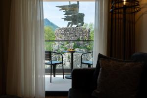 a room with a window with a table and chairs at Hotel De‘Andros Virpazar in Virpazar