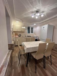 a kitchen and dining room with a table and chairs at Orchidea Guest House in Kutaisi +22 photos