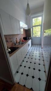 a kitchen with a black and white tiled floor at Wanta 2 Kołobrzeg in Kołobrzeg