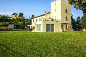 une grande pelouse devant un bâtiment dans l'établissement Villa la torre, à Montespertoli