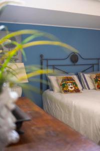 sypialnia z 2 łóżkami i niebieską ścianą w obiekcie Guest House Antichi Ulivi w mieście Mondello
