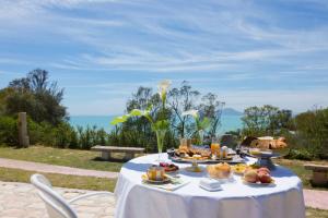 uma mesa com comida com o oceano ao fundo em Lella Kmar B&B avec piscine Sidi Bou Said em Sidi Bou Saïd