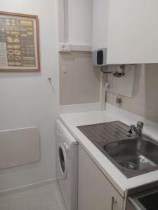 een witte keuken met een wastafel en een vaatwasser bij PCQ Apartments - Centro Città in Genua