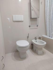 een witte badkamer met een toilet en een wastafel bij PCQ Apartments - Centro Città in Genua