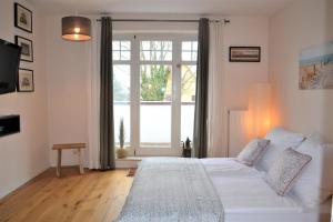 um quarto com uma grande cama branca e uma janela em Kaethchen em Warnemünde