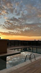 einen Pool auf einem Gebäude mit Sonnenuntergang in der Unterkunft Inova Flats premium no Condominio Cosmopolitan in Palmas