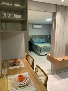 Zimmer mit einem Esstisch und einem Bett in der Unterkunft Inova Flats premium no Condominio Cosmopolitan in Palmas