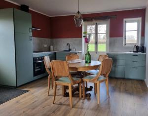 a kitchen with a table with chairs and a vase with flowers at Le Montaurier in Combrailles