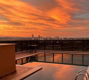 Sonnenuntergang auf dem Dach eines Gebäudes mit Pool in der Unterkunft Inova Flats premium no Condominio Cosmopolitan in Palmas