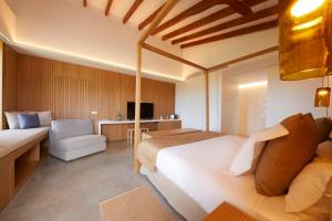 a hotel room with a large bed and a chair at Finca Sestelrica in Artá