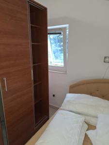 sypialnia z szafą, 2 łóżkami i oknem w obiekcie Apartment Bicky w mieście Bijela