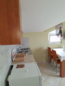 a kitchen with a stove and a table with chairs at Apartment Bicky in Bijela