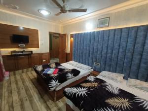 a hotel room with two beds and a couch at Valley holidays in Srinagar