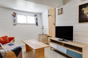 ein Wohnzimmer mit einem TV und einem Tisch in der Unterkunft Péniche Destinée in Bordeaux