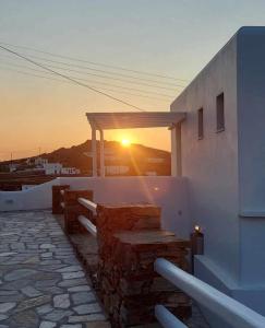 a sunset on the side of a building with the sun setting at Seascape, apartment with sea view 1 in Áno Meriá
