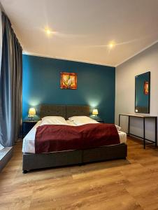 a bedroom with a large bed with a blue wall at Trip Inn Hotel Düsseldorf Neuss in Neuss