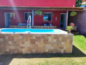 a swimming pool in front of a house at Studio Mar & Sol in Armacao dos Buzios