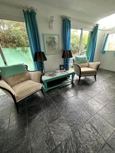 een woonkamer met 2 stoelen en een tafel bij Hotel Donatella mare boutique in Punta del Este
