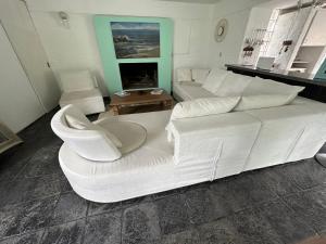 un divano bianco e sedie in soggiorno di Hotel Donatella mare boutique a Punta del Este