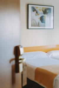 1 dormitorio con 1 cama y una foto en la pared en Hotel Zaragoza Plaza, en San Sebastián