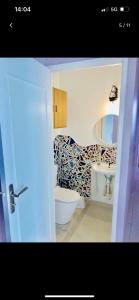 La salle de bains est pourvue de toilettes et d'un lavabo. dans l'établissement Chambre artistique entre Disneyland et Paris, à Neuilly-sur-Marne