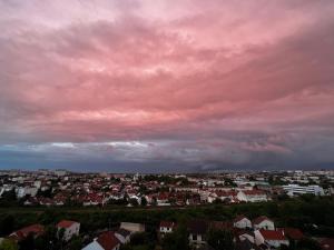 a city under a pink cloudy sky with houses at Chambre artistique entre Disneyland et Paris in Neuilly-sur-Marne