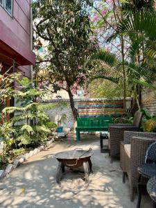 um pátio com uma mesa verde e cadeiras em Assam Home Hostel Project em Guwahati