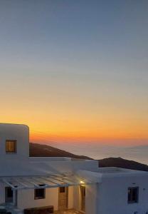 una puesta de sol de una casa blanca con el cielo en Seascape suite 2 with sea view, en Áno Meriá