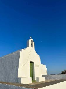 a white church with a cross on top of it at Seascape, apartment with sea view 2 in Áno Meriá