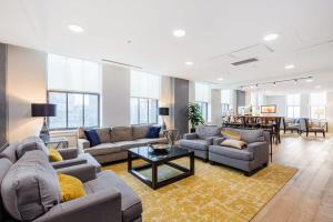 a living room with couches and a table at 2B 2BA Distinguished Apartment Rooftop Pool & Gym in Baltimore