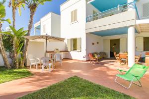 eine Terrasse mit Stühlen und Tischen in einem Haus in der Unterkunft Villetta Relax With Pool in Residence - Happy Rentals in Melendugno