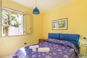 ein Schlafzimmer mit einem blauen Bett und einem Fenster in der Unterkunft Villetta Relax With Pool in Residence - Happy Rentals in Melendugno + 28 Fotos