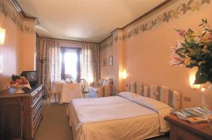 a hotel room with a bed and a television at Hotel Relais Des Alpes in Madonna di Campiglio