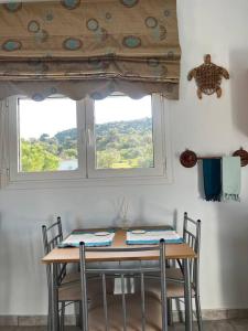 een tafel en stoelen in een kamer met een raam bij Shells_Haven in Skála Néon Kydonión