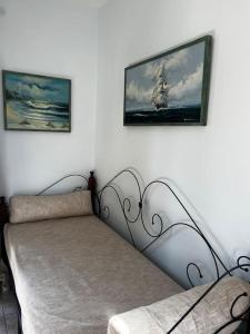 een bed in een kamer met twee foto's aan de muur bij Shells_Haven in Skála Néon Kydonión