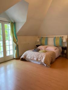 ein Schlafzimmer mit einem Bett und einem großen Fenster in der Unterkunft Belle et calme maison de campagne in Artannes-sur-Indre