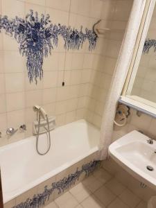 un bagno bianco con vasca e lavandino di Casa Viola a Cortina dʼAmpezzo