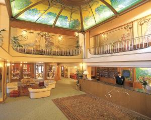 eine große Lobby mit einer großen Glasdecke und einem Gebäude in der Unterkunft Hotel Relais Des Alpes in Madonna di Campiglio